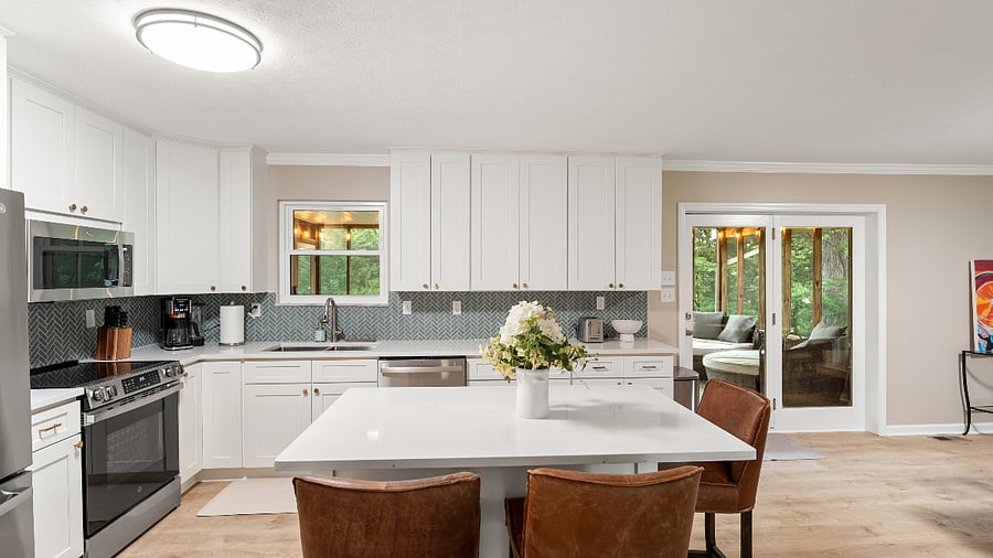 Kitchen leads to large outdoor screened deck.