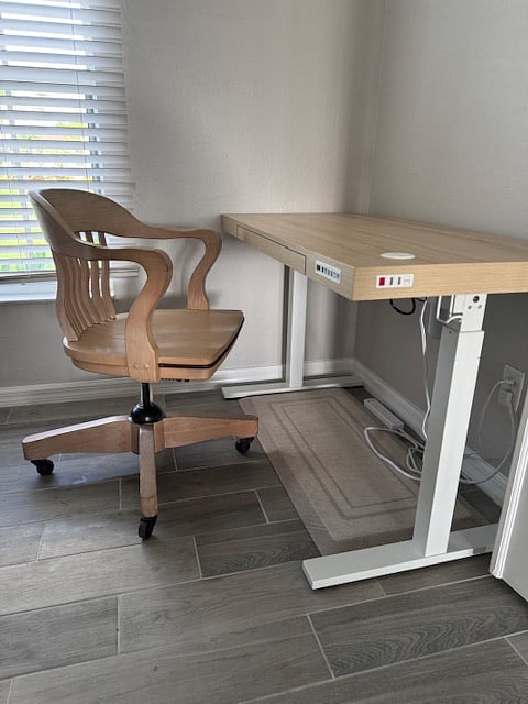 Motorized adjustable sit/stand desk with anti fatigue mat.