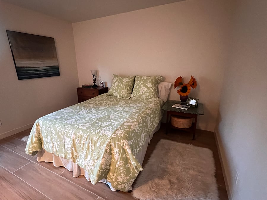 A full-size bed with loads of space, a sitting area, and floor-to-ceiling double mirrored closet doors with loads of space for clothing, suit cases, and more. 
