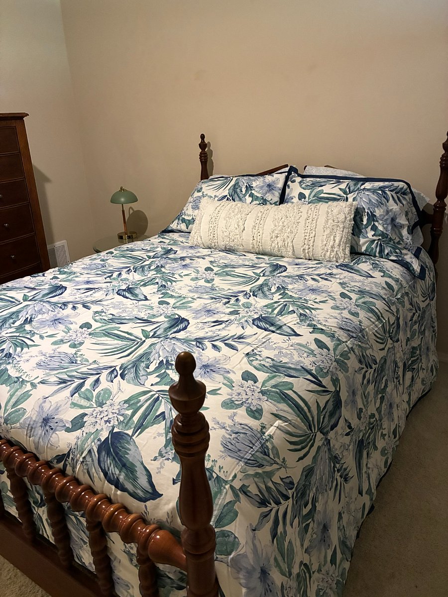 view from the double closet of bed and dresser