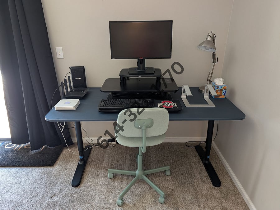 Standing desk with 24-in computer monitor, laptop stand, and keyboard