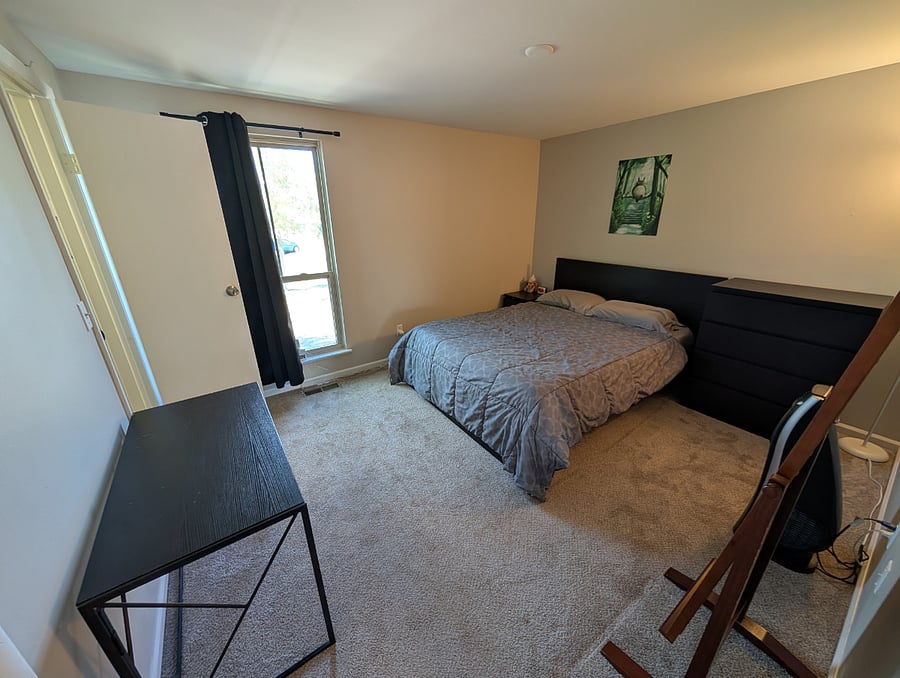 Primary Bedroom with queen sized bed, dresser, nightstand, desk, and full length mirror.