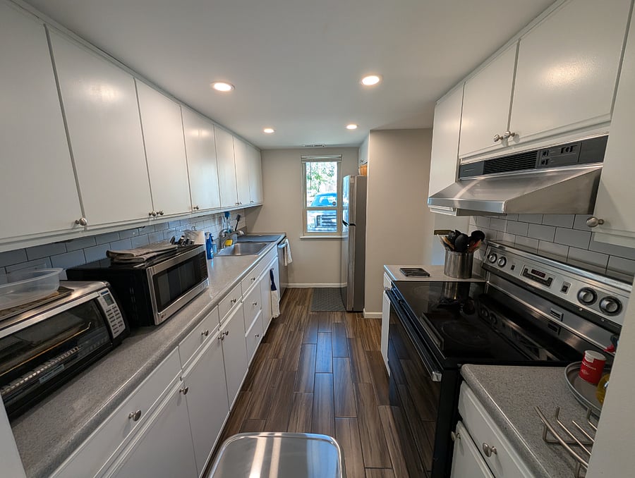 Kitchen with refrigerator, electric stove/oven, dishwasher, coffee maker, microwave, and toaster oven.