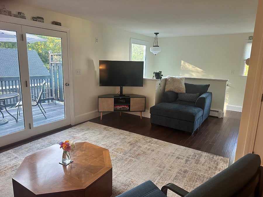 Living Room with Plush Chair and Storage Ottoman and Smart TV.