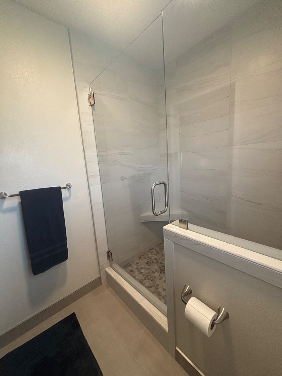 Glass shower door with pebble stone base