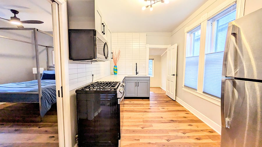 The upper unit kitchen has designer feel with tile to the ceiling and quarts countertops
