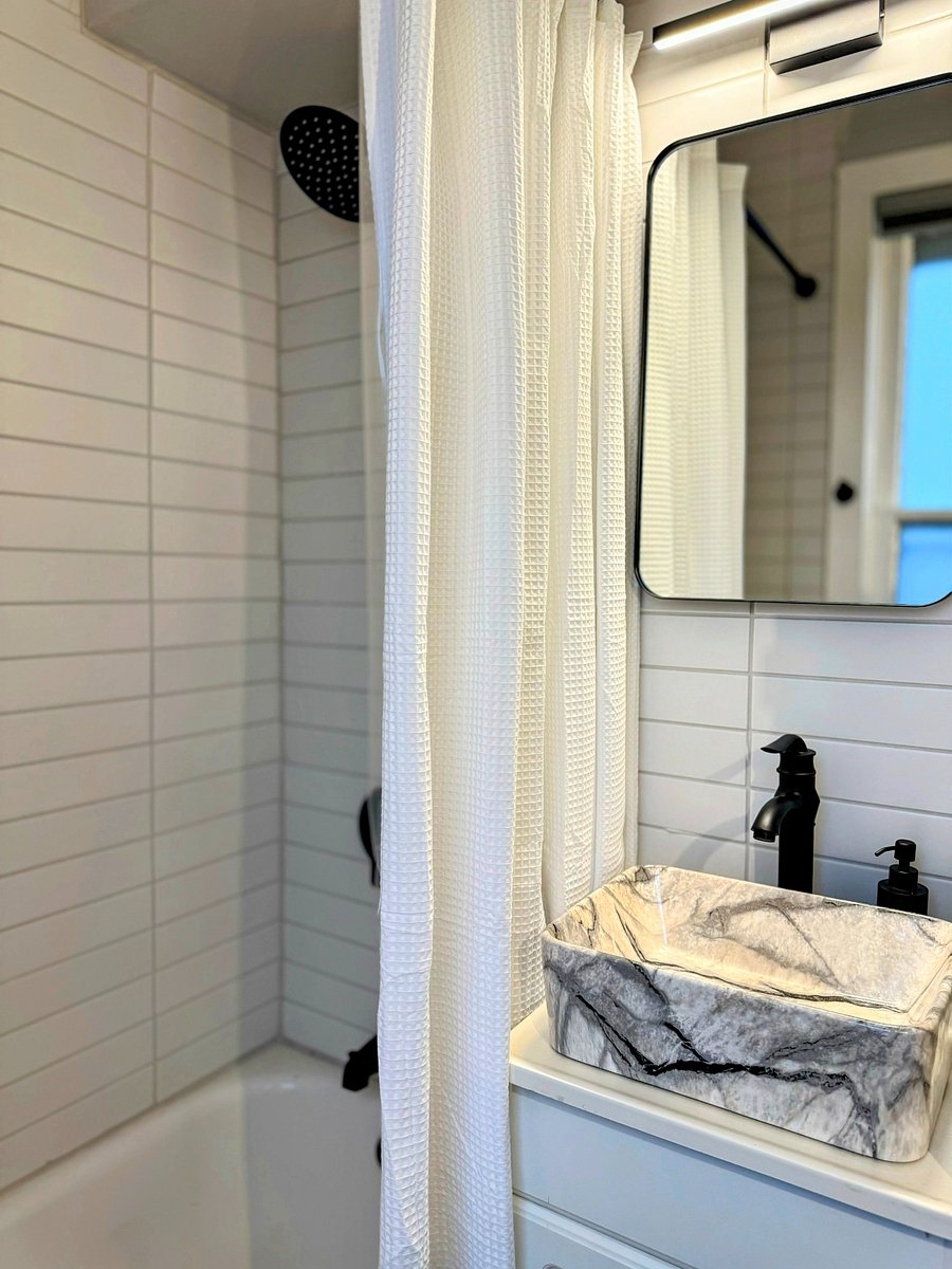 The upper unit bathroom had modern matte black fixtures, unique vessel sink and nice soaking tub