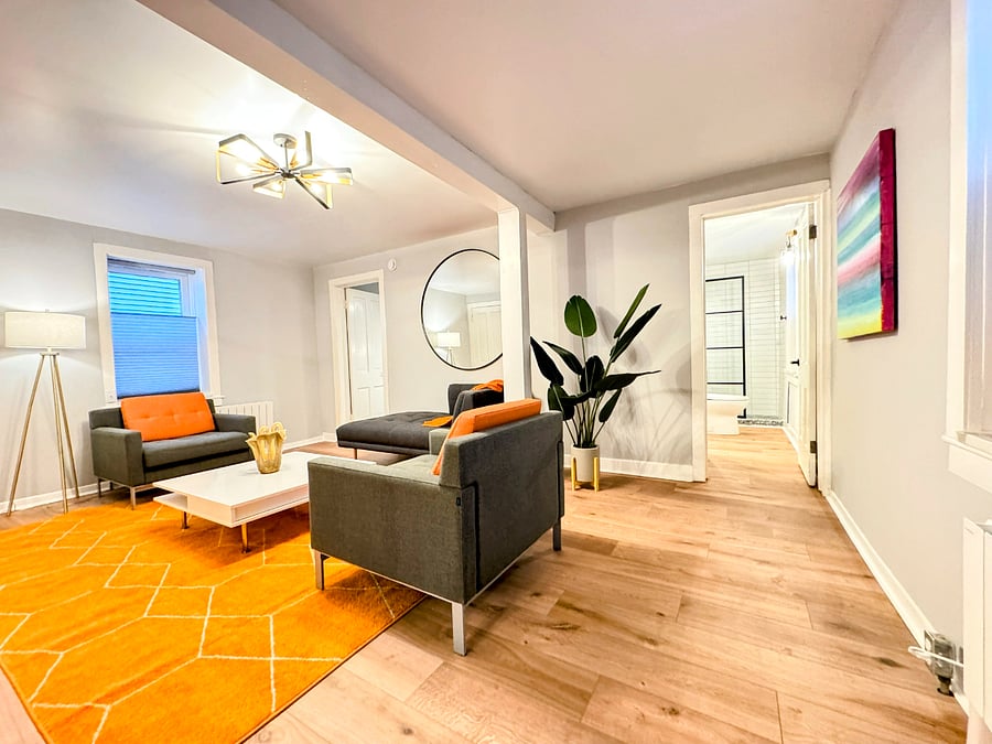 The lower unit has a large open living room with modern furniture and Smart TV
