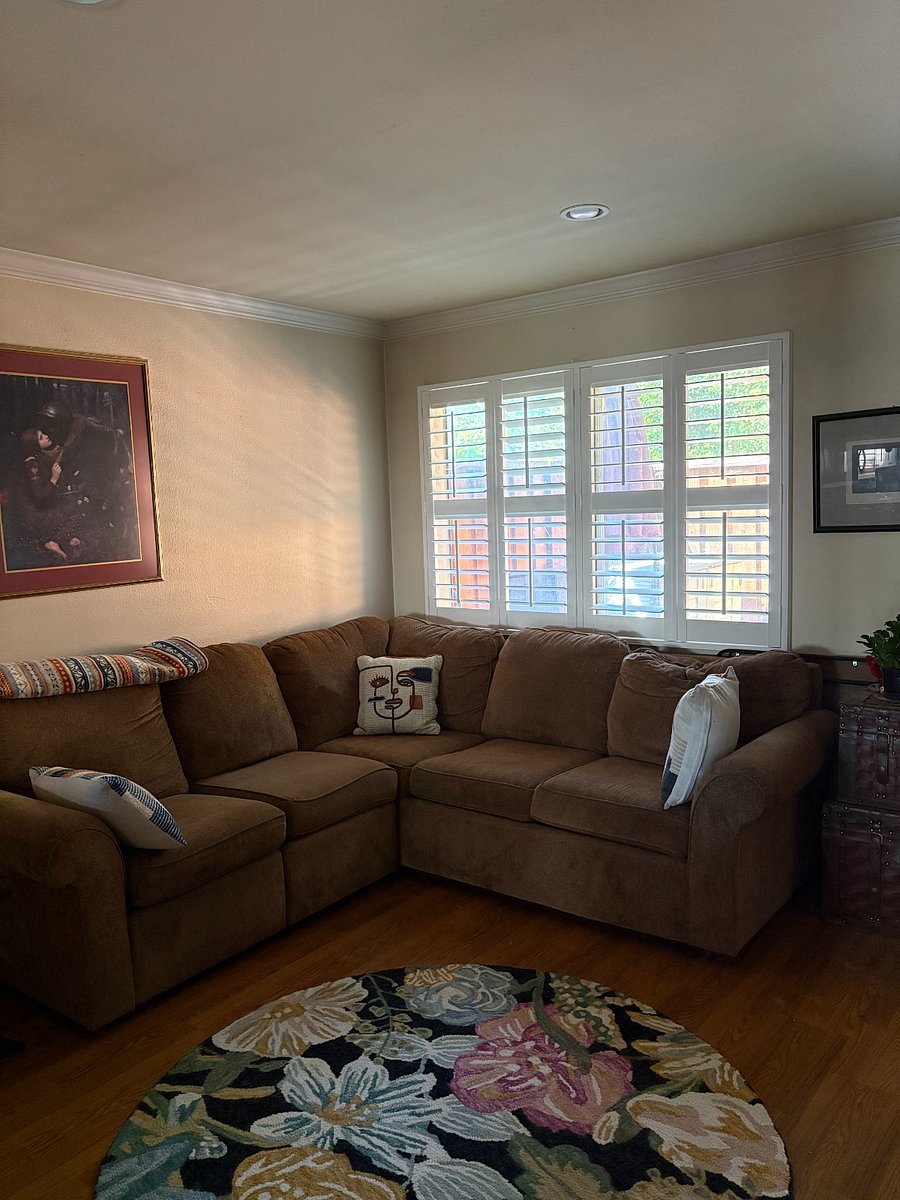 Bright living room with wraparound couch. Couch has built in recliner. 