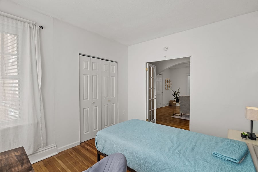 FRONT BEDROOM with night stand, side table with lamp having USB power outlet. Reading table, closet, and calming curtains.