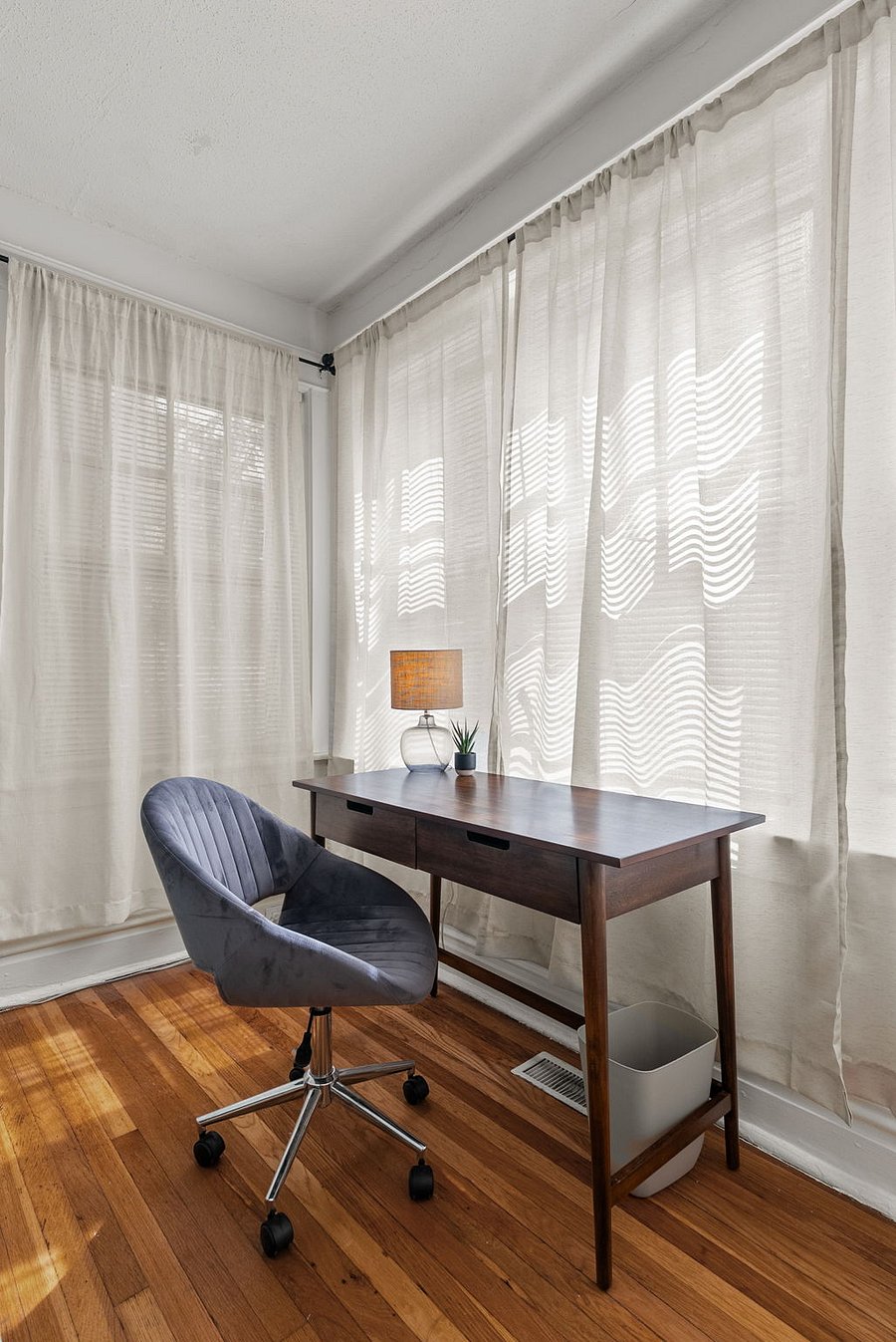 FRONT BEDROOM Wood writing desk with chair and lamp