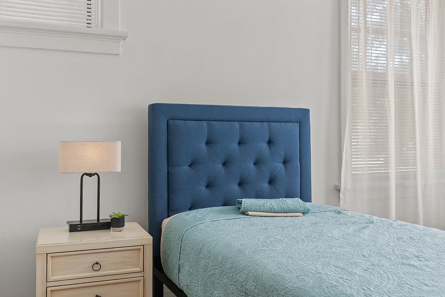 FRONT BEDROOM with night stand, side table with lamp having USB power outlet. Reading table, closet, and calming curtains.