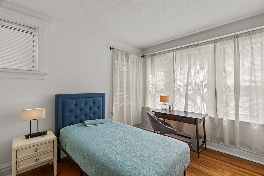 FRONT BEDROOM with night stand, side table with lamp having USB power outlet. Reading table, closet, and calming curtains.