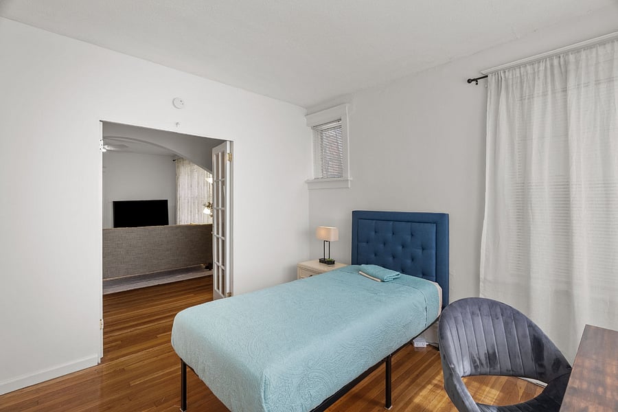 FRONT BEDROOM with night stand, side table with lamp having USB power outlet. Reading table, closet, and calming curtains.