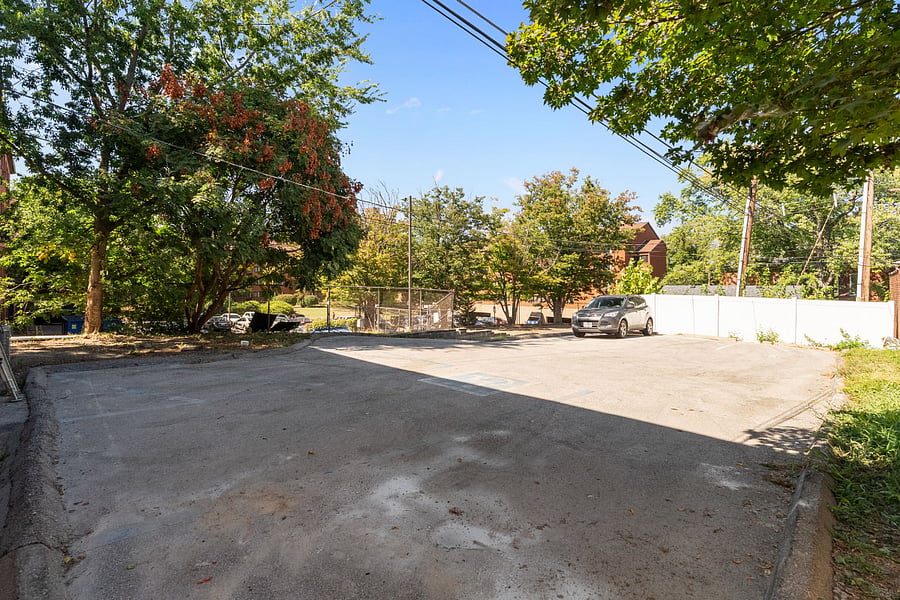 Attached parking lot with designated parking spots. Flood light illuminates the lot at night