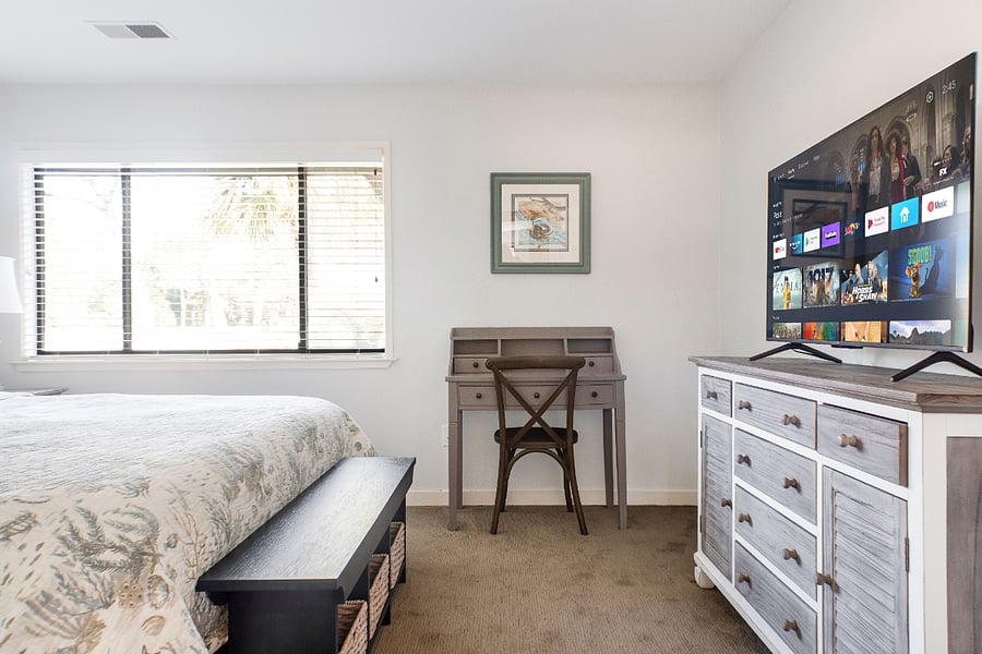 Bedroom with King bed and 50 inch Smart TV and workspace desk.