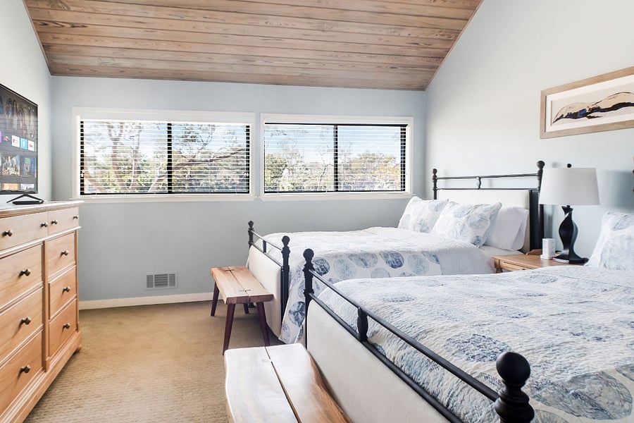 Upstairs bedroom with two queen beds, 45 inch Smart Roku TV, and walk-in closet
