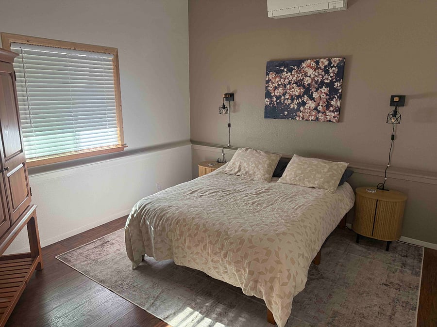 Queen bed with charging station on night stand.