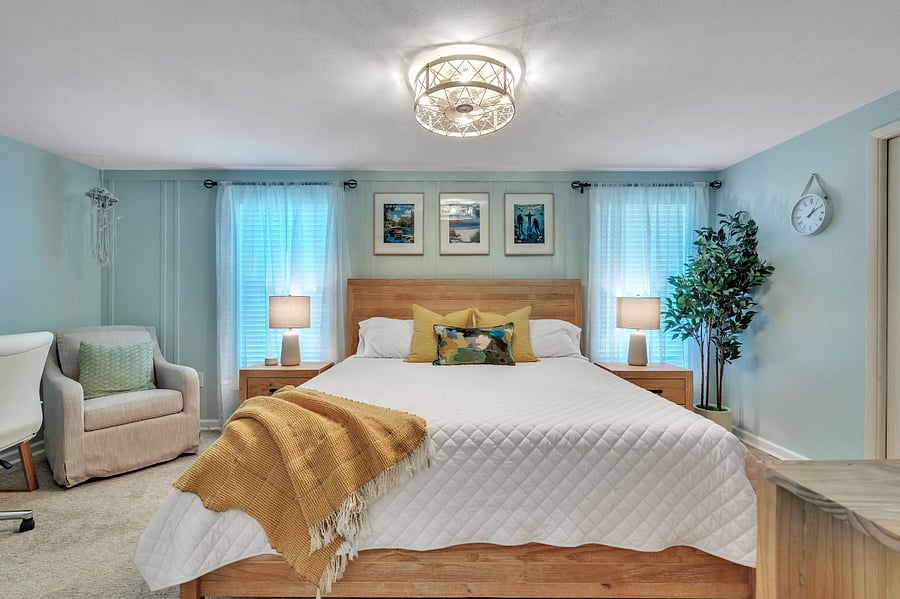 Master bedroom with pillow top king sized bed, wall mounted smart TV, extra large walk-in closet with built-in storage, large dresser and mirror, full sized glass desk and rolling office chair, plush rocking chair in cozy nook with ottoman, perfect for reading and relaxing. 