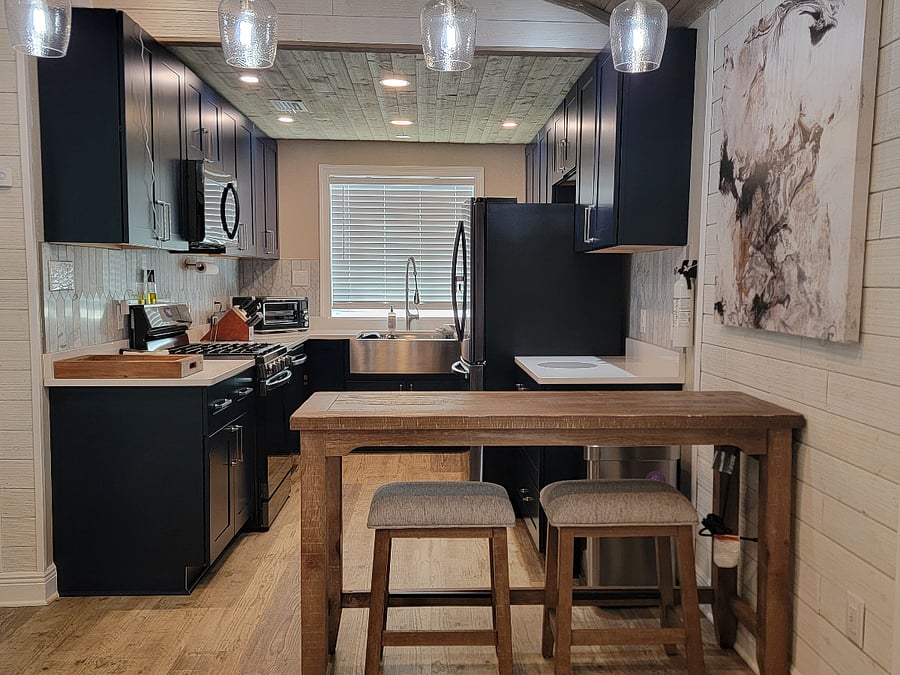 Full kitchen with high top dining table that can double as a work area