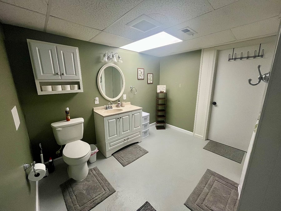 Large bathroom with a shower, shampoo, conditioner, body wash, hand soap, towels and cleaning supplies provided. There's also a small storage space available under the stairs.