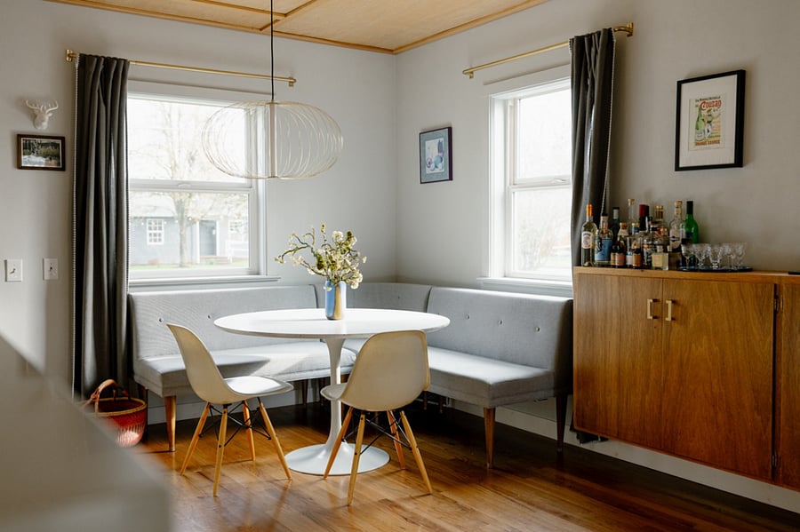 Open kitchen connects to dining room with banquette.