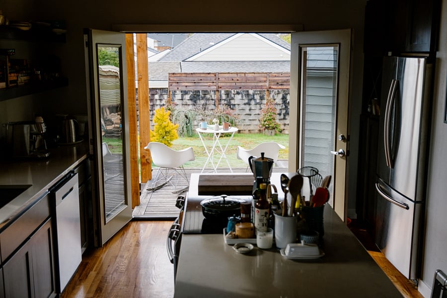Kitchen opens up to back deck and yard through a set of French doors.