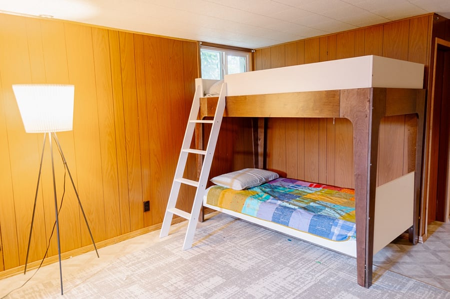 The basement is a large, funky space reminiscent of the Brady Bunch era. 
The main space is an open room with a set of twin bunkbeds.