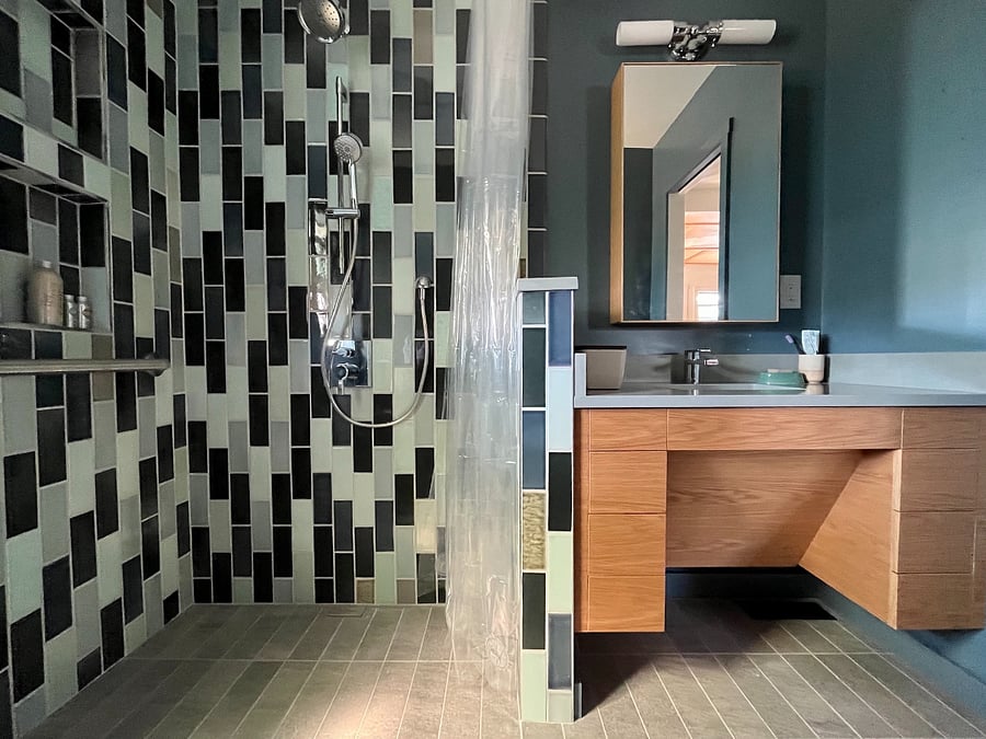 Shower is fully tiled and includes a blind drain for water, shower wand and grab bar. 