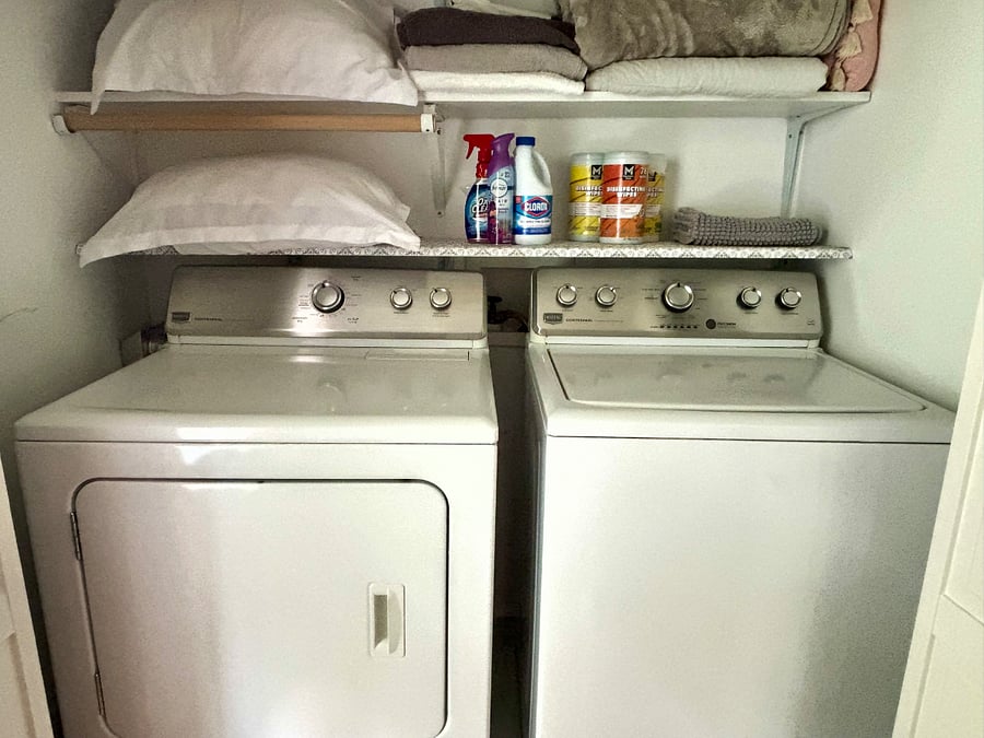 In unit, Maytag washer and dryer with storage above.