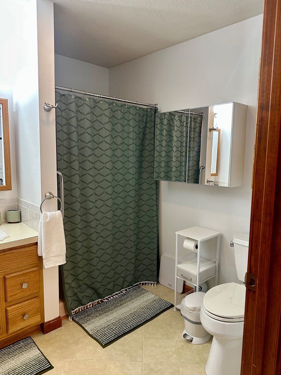 Full size walk-in shower with grab bars (no tub).