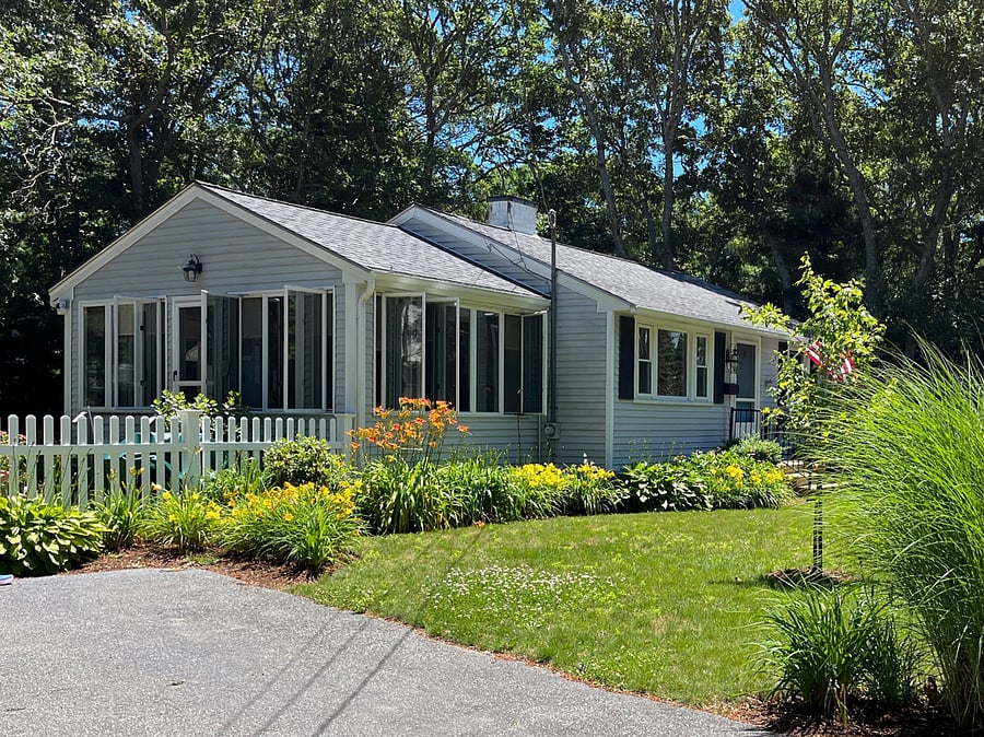 cottage with driveway parking and fenced yard