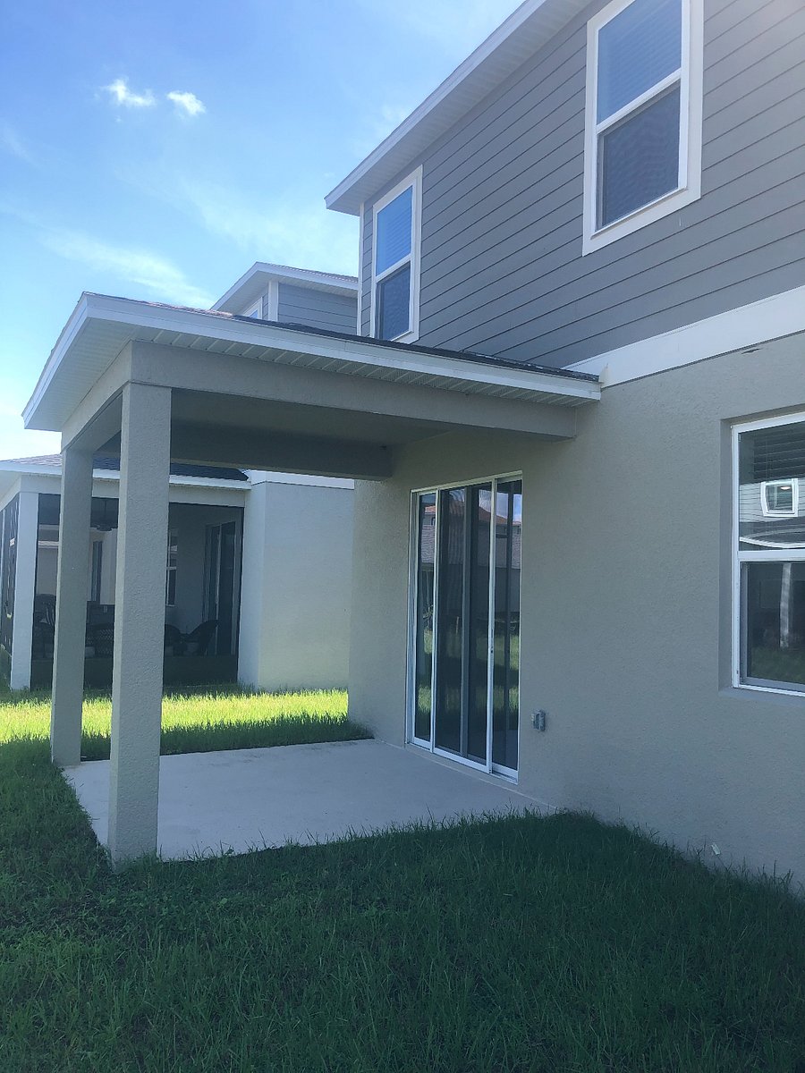 There is a covered back patio with a table and chairs.