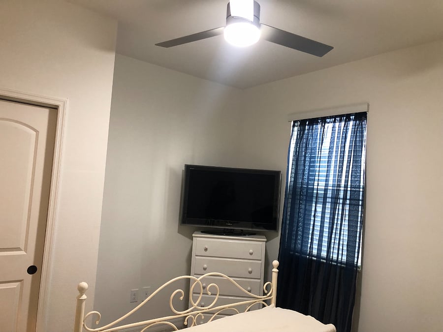 This is the downstairs bedroom. It has an adjacent bathroom. The ceiling fan/light is remote controlled. The TV has Roku.