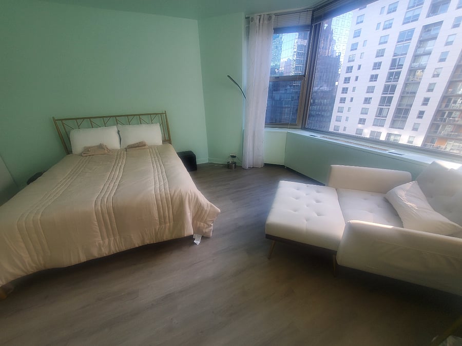 Bedroom is spacious with a queen bed and lounge chair and still a lot of space