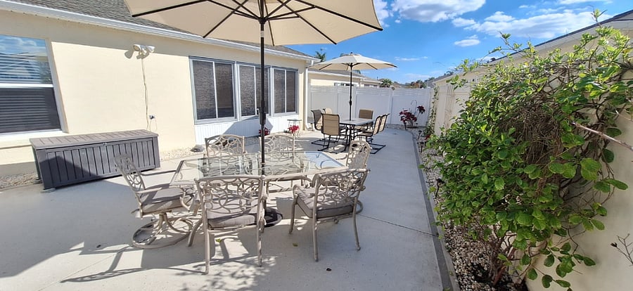 Walled Patio with (2) 6 seat patio table with umbrellas