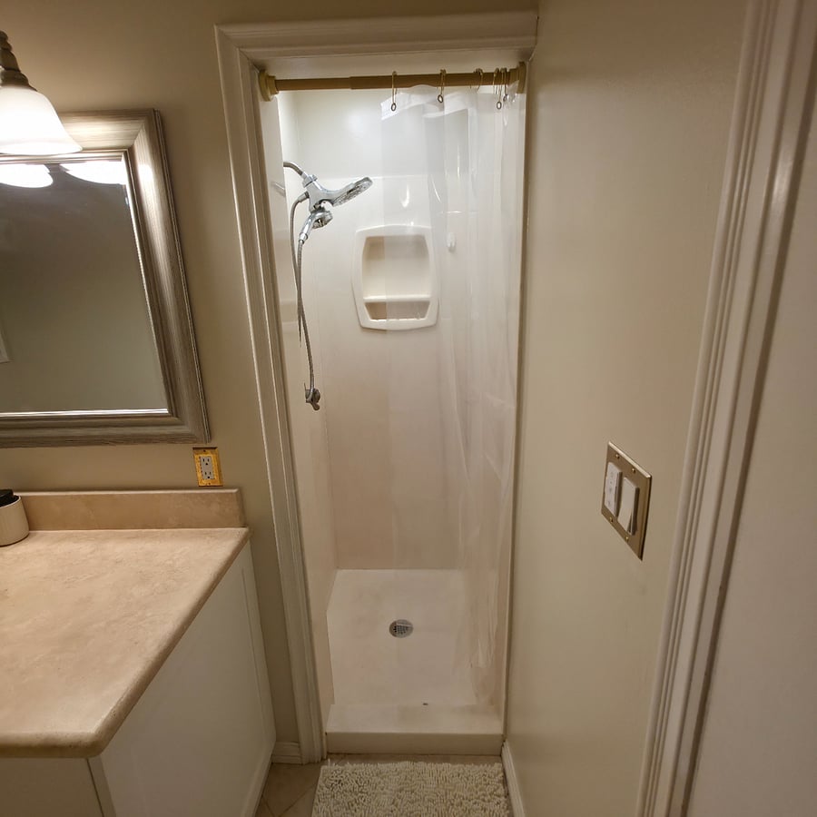 Walk in shower stall with exhaust fan and light. 
