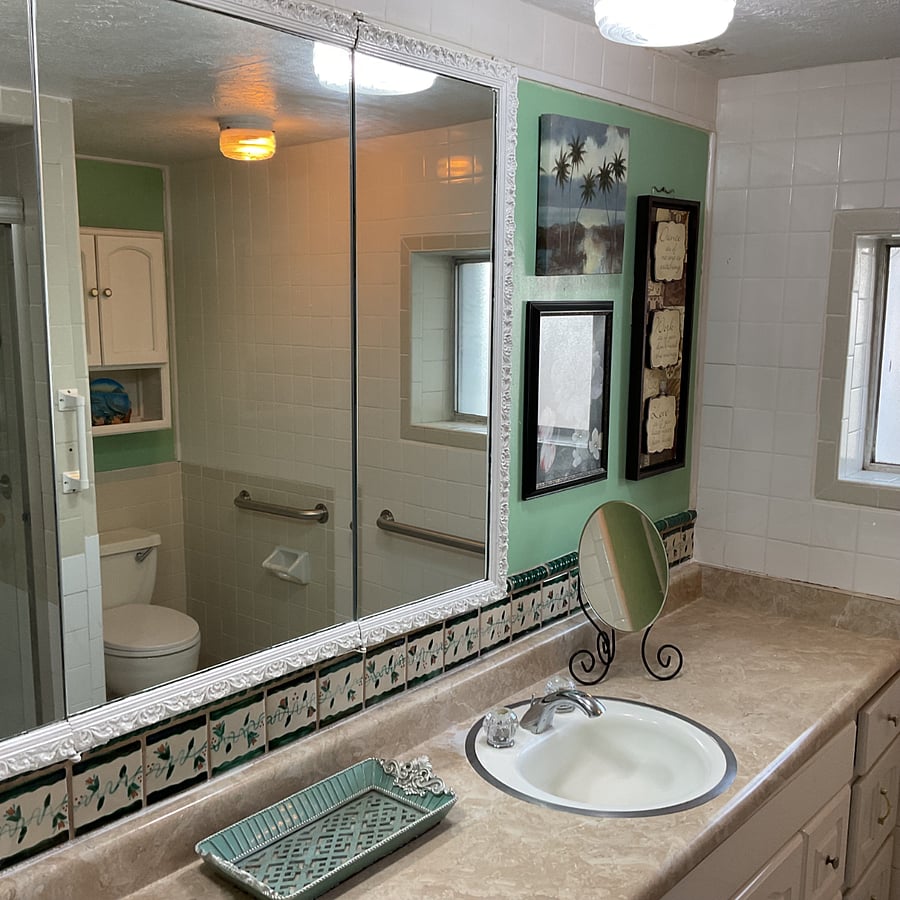 Downtstairs bathroom featuring a shower, toilet, linen closet and double sink vanity.