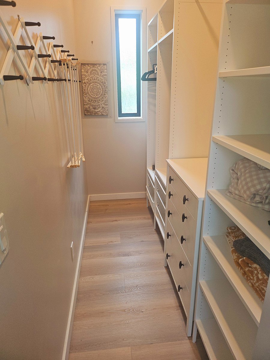 Expansive walk-in closet designed with abundance of storage space.