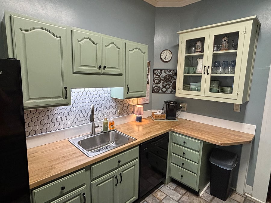 Remodeled kitchen with new butcher block countertops and tile backsplash.