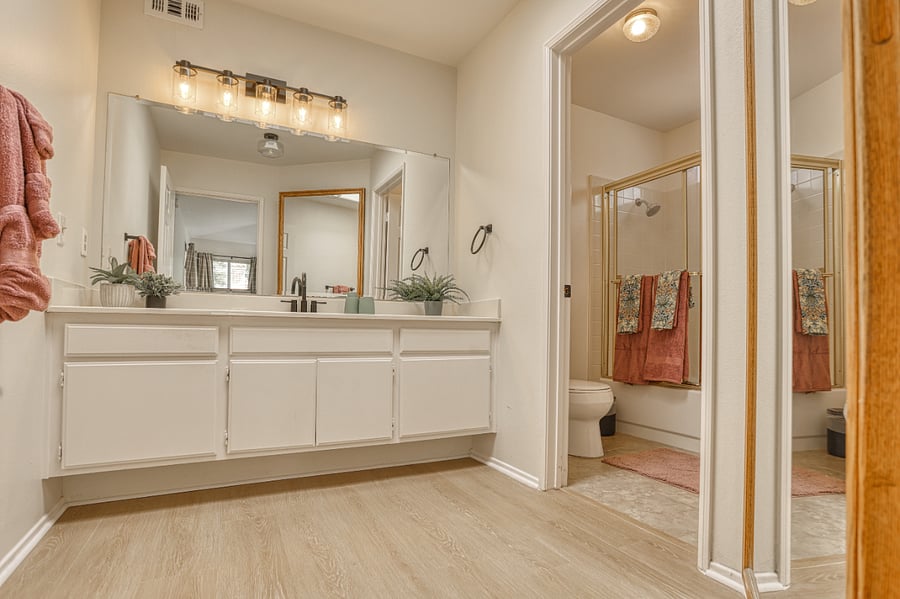 Enjoy the convenience of a large, modern bathroom featuring a wide double-sink vanity and expansive mirrorperfect for getting ready without the morning rush.
