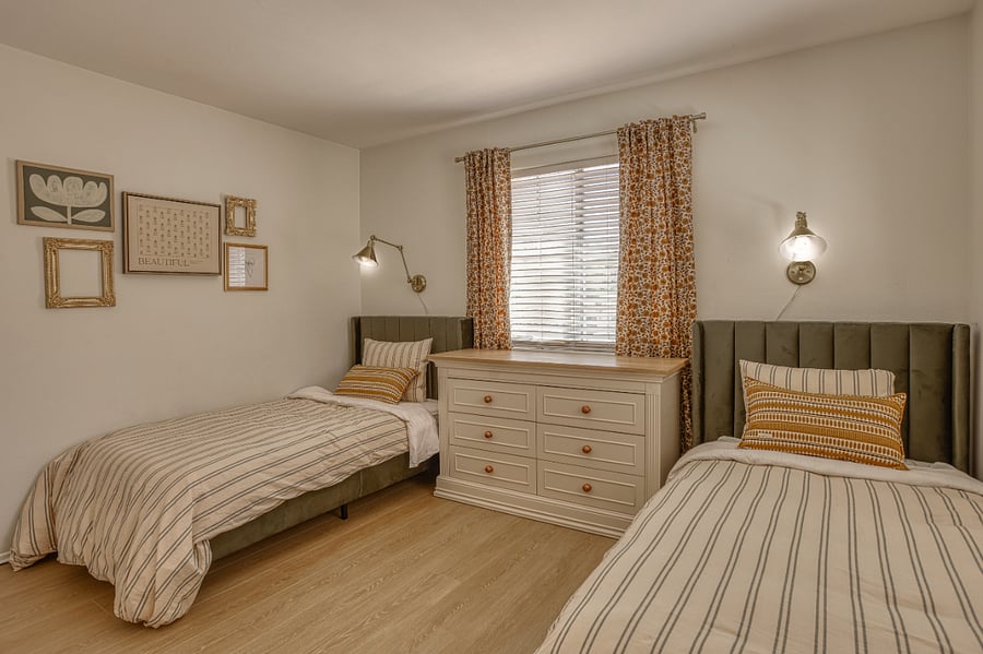 Perfect for friends, siblings, or solo travelers, this inviting second bedroom features two comfortable twin beds and a warm, curated design. The mix of patterns and textures creates a cozy "home away from home" feeling that guests will love.