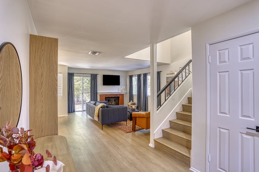 Step into this airy and sun-filled living area, where a seamless flow and high ceilings create a sense of grand comfort. The open-concept design ensures that whether you're relaxing on the sofa or moving through the home, you always feel connected to the heart of the space.