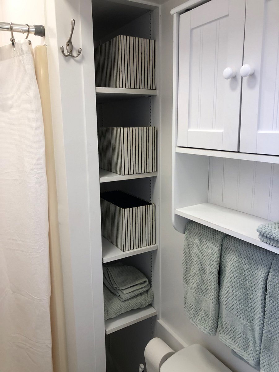 Bathroom. Shower curtain. Shelving. Medicine cabinet above toilet.