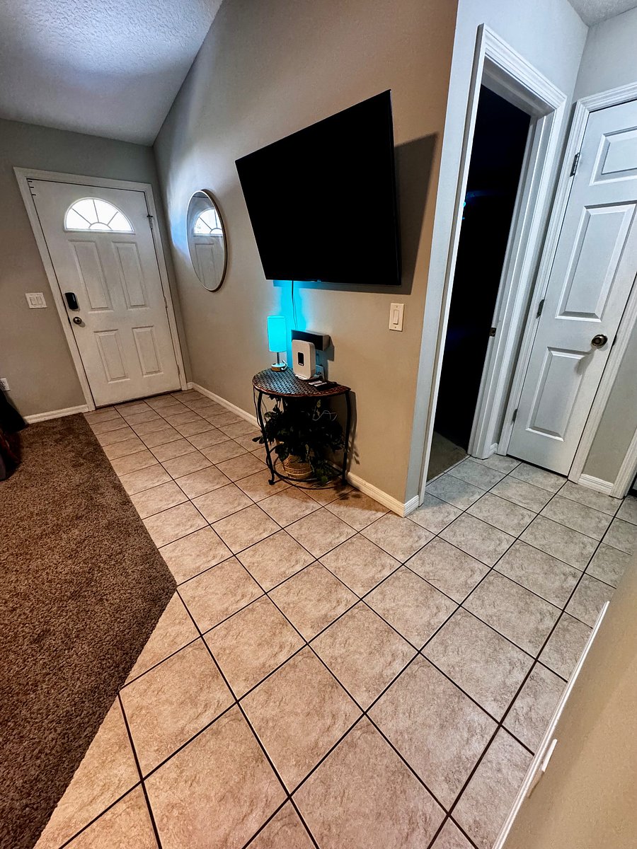 View of front door and hall to access master suite, bedroom 2, and the spare bathroom.