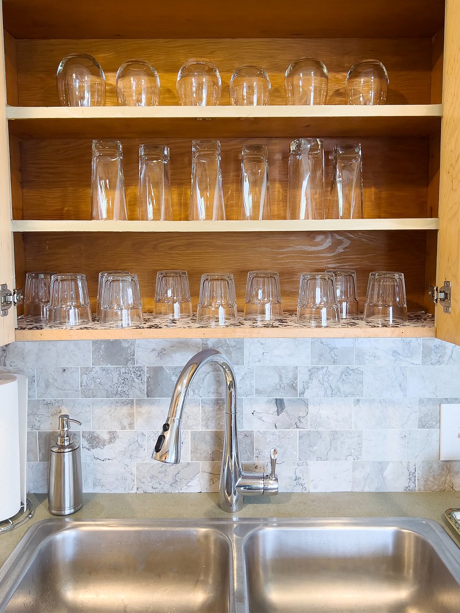 Drinkware is located above the sink.