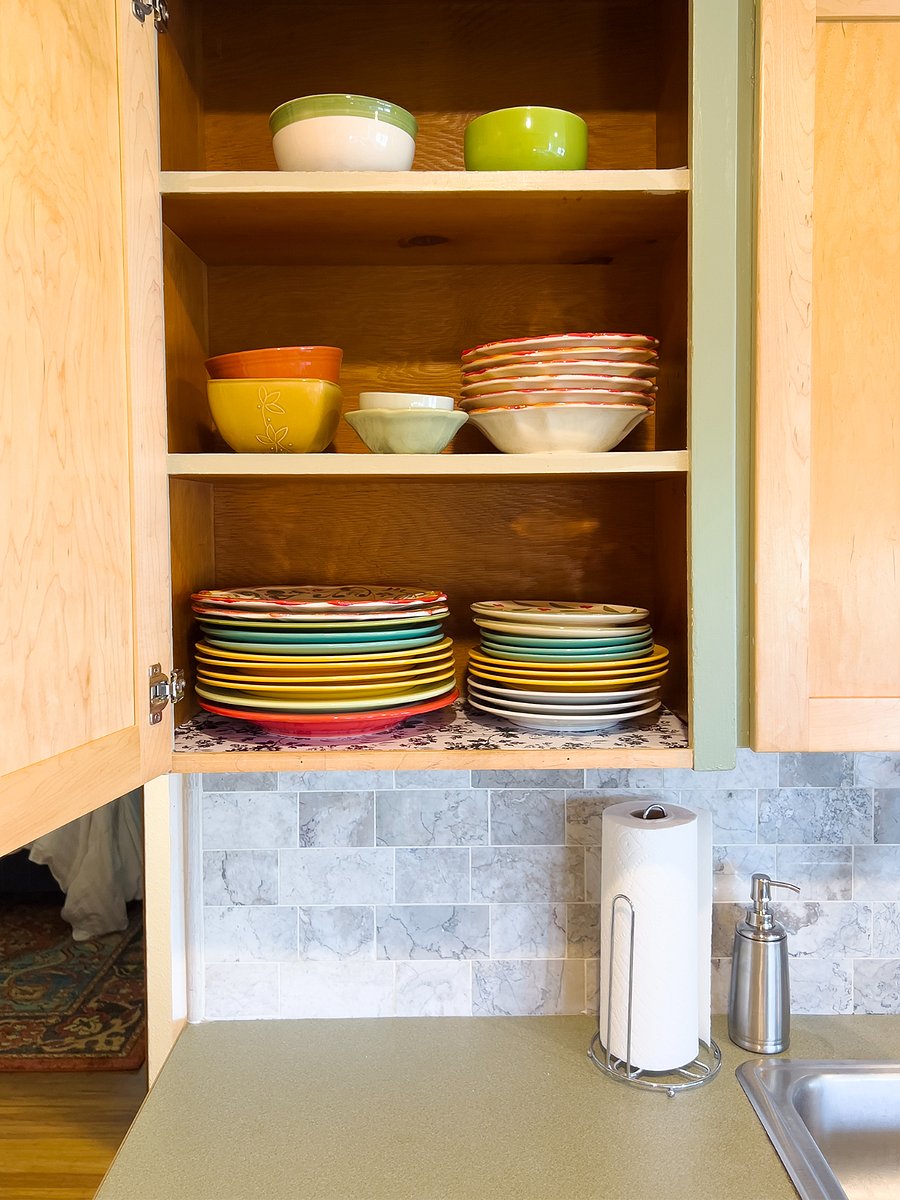 Plates and bowls are located next to the sink.