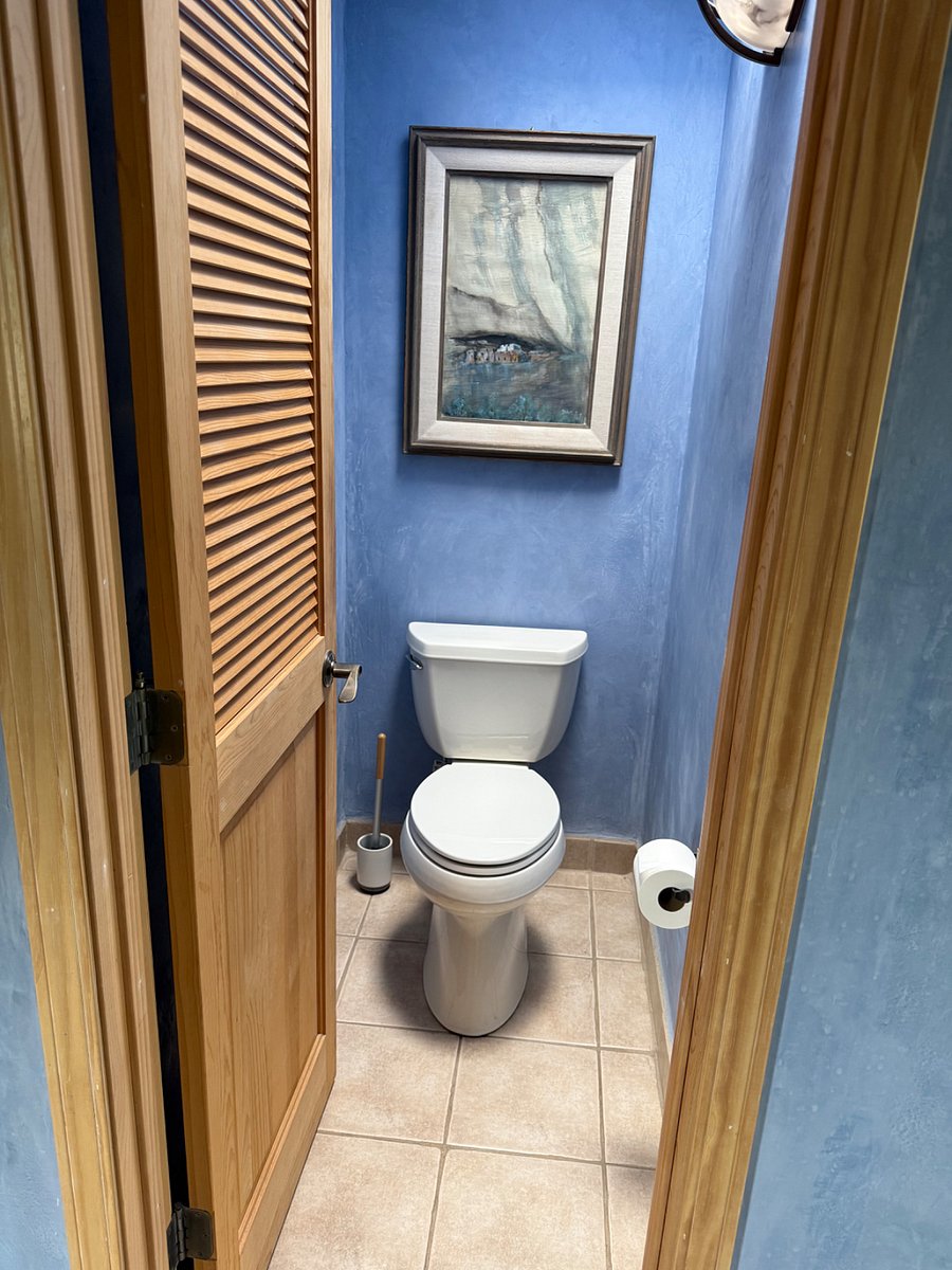 Privacy door on toilet room in large bathroom.