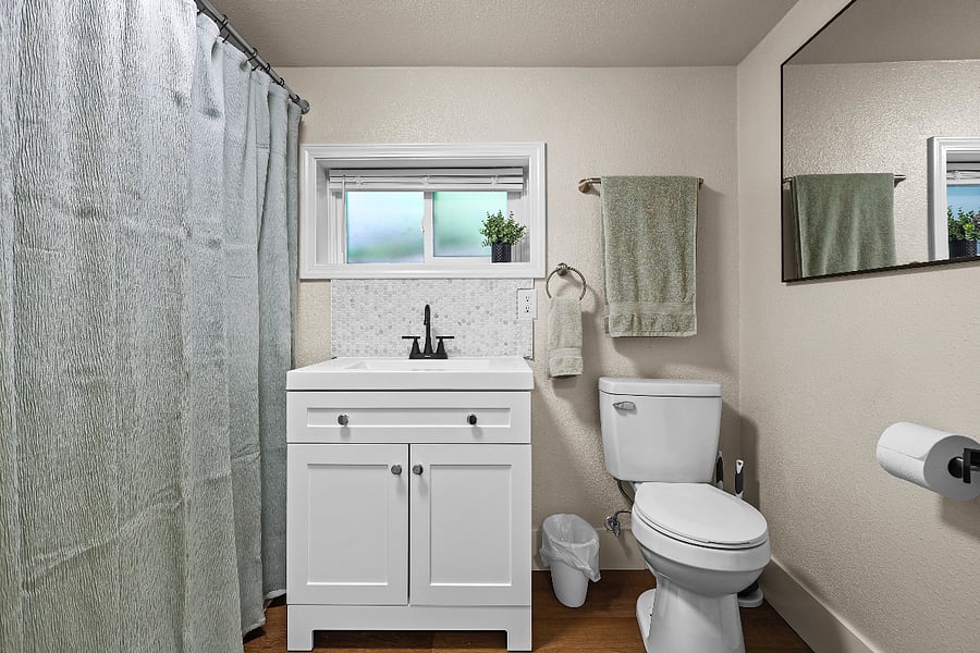 Extra storage caddy and towel hook behind bathroom door.