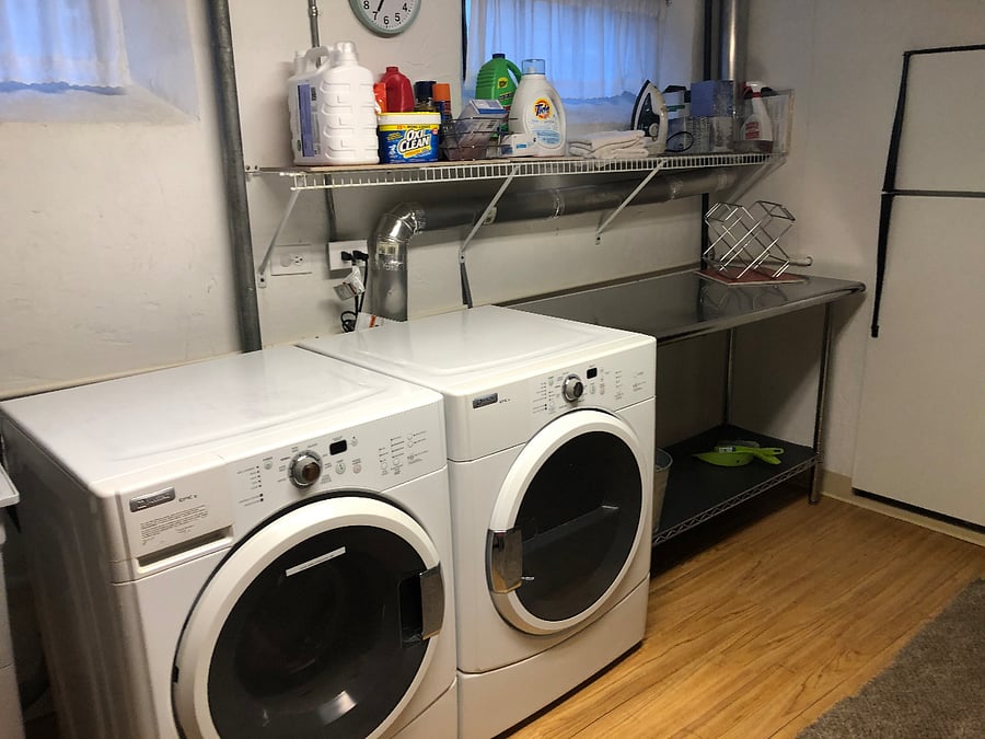 Spacious laundry room in basement with storage.